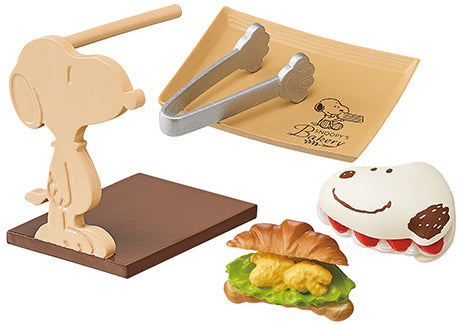 SNOOPY'S BAKERY Re-ment Blind Box Series featuring various toy designs, including a croissant sandwich, stuffed animal, and pair of tongs.