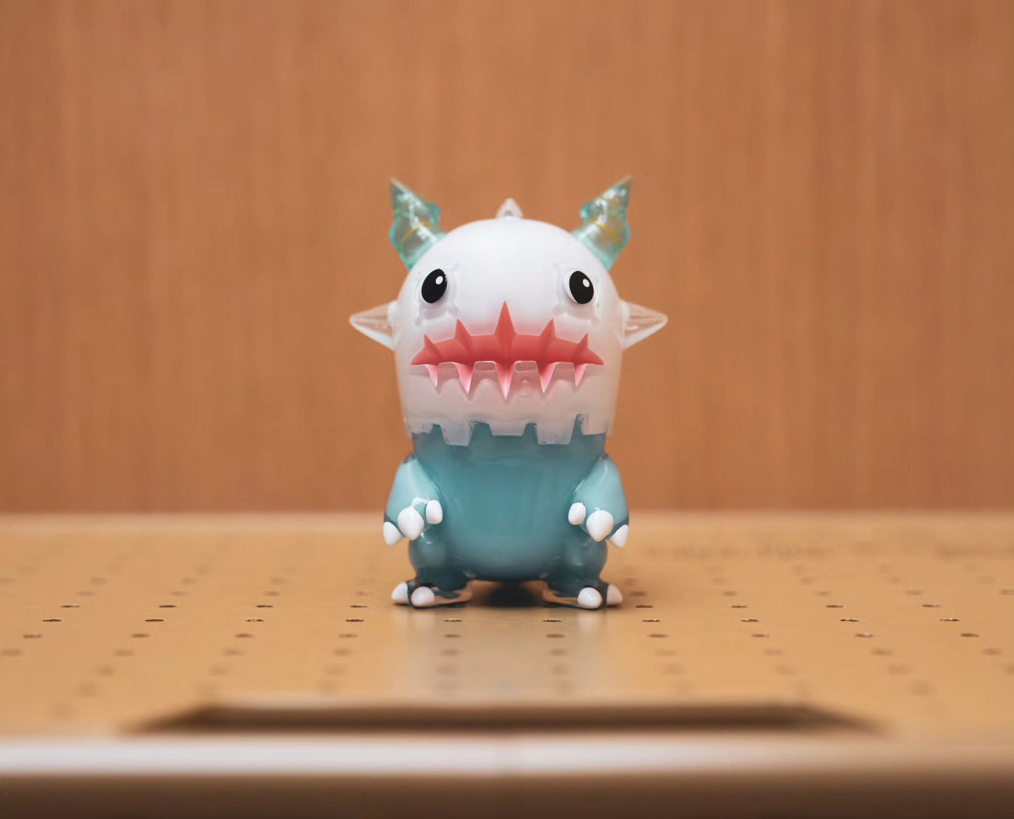 TEBODINO by Odom, a soft vinyl toy figurine with a white face, horns, and teeth, measuring 10.5cm, displayed on a table.