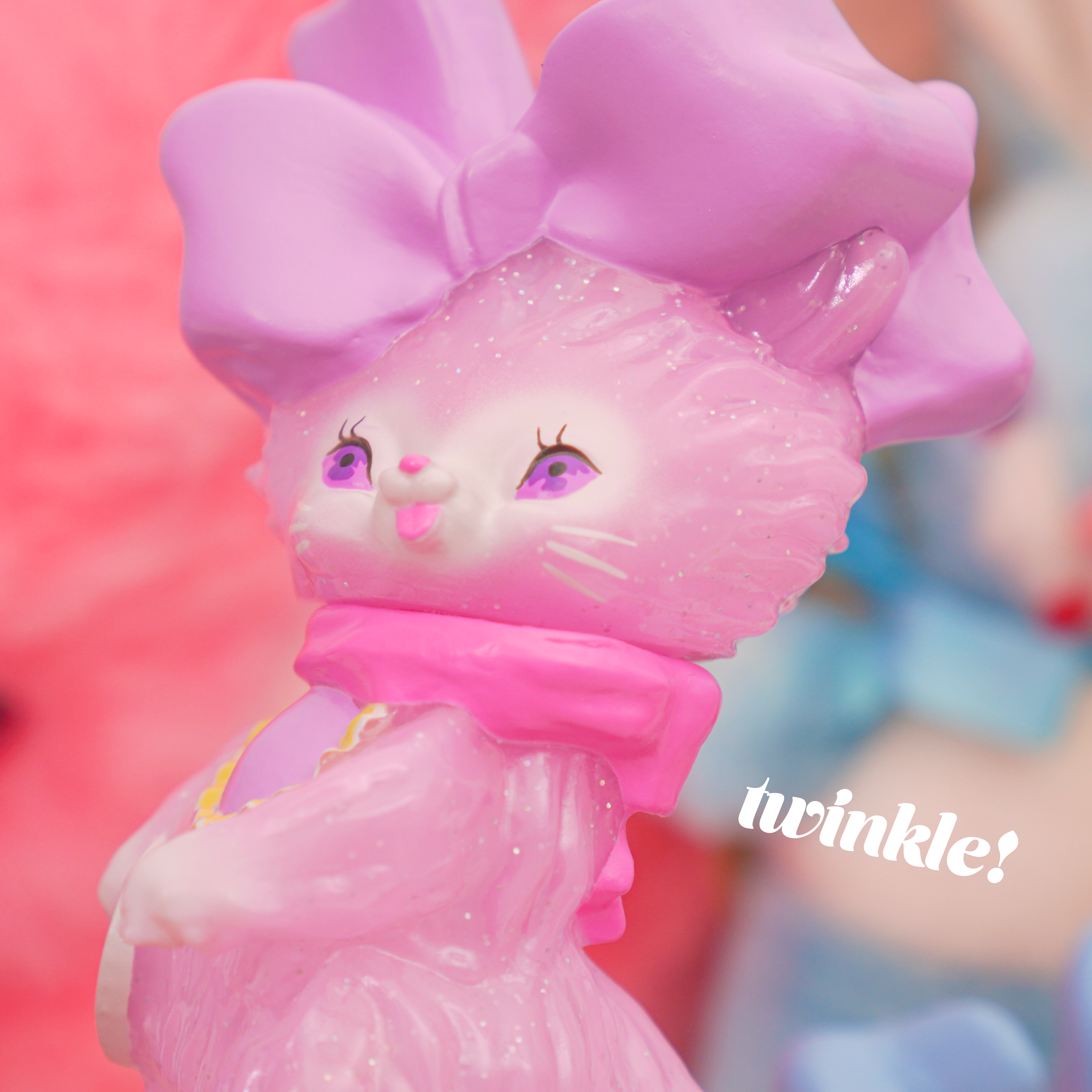 Bab Kat - Sugar Sweet Pea by Ms LUTRA, a 130mm Sofubi pink cat figurine with a bow, features intricate details like its distinct purple and black eyes.