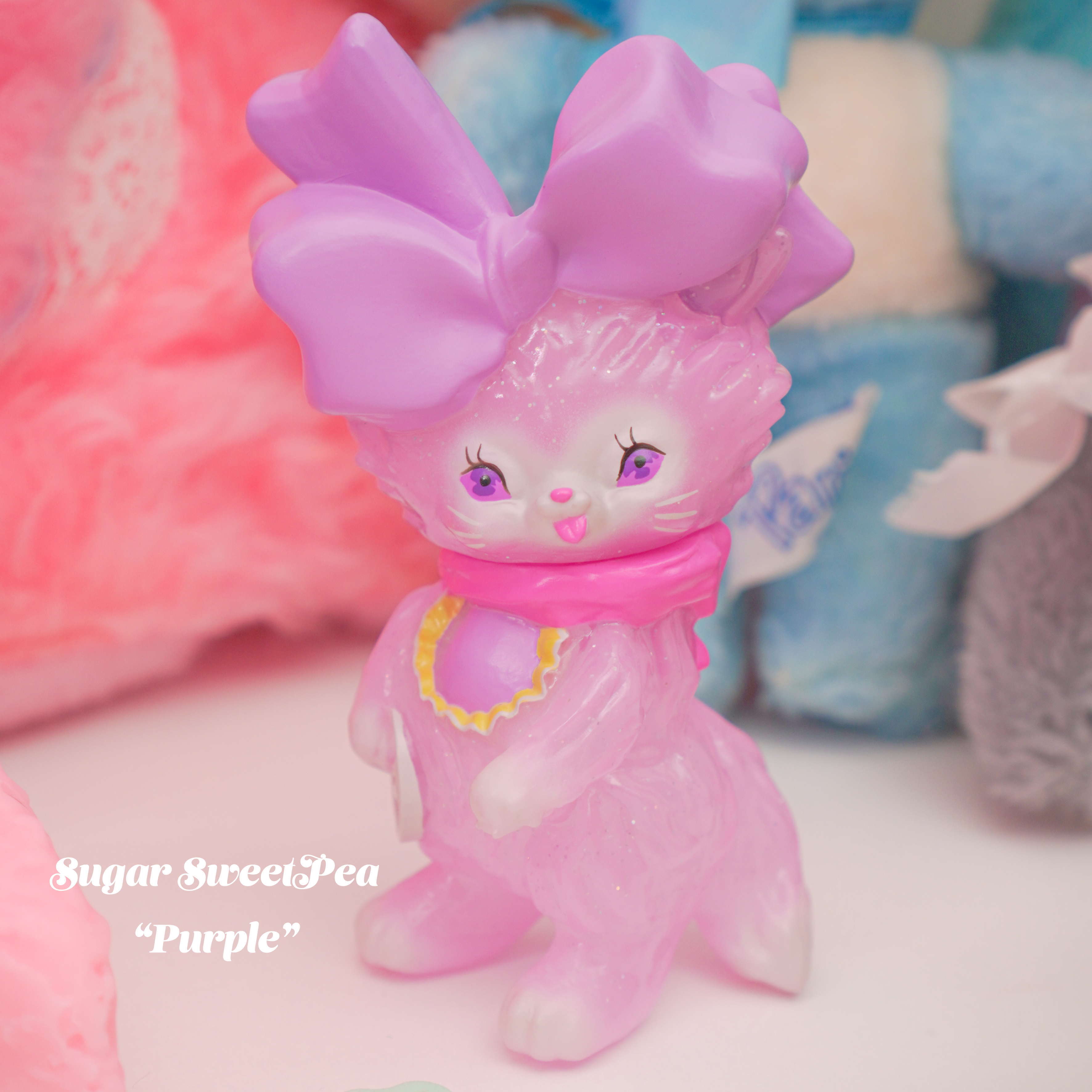 Bab Kat - Sugar Sweet Pea by Ms LUTRA, a 130mm pink sofubi cat toy, features a bow and cartoon-style plush design.