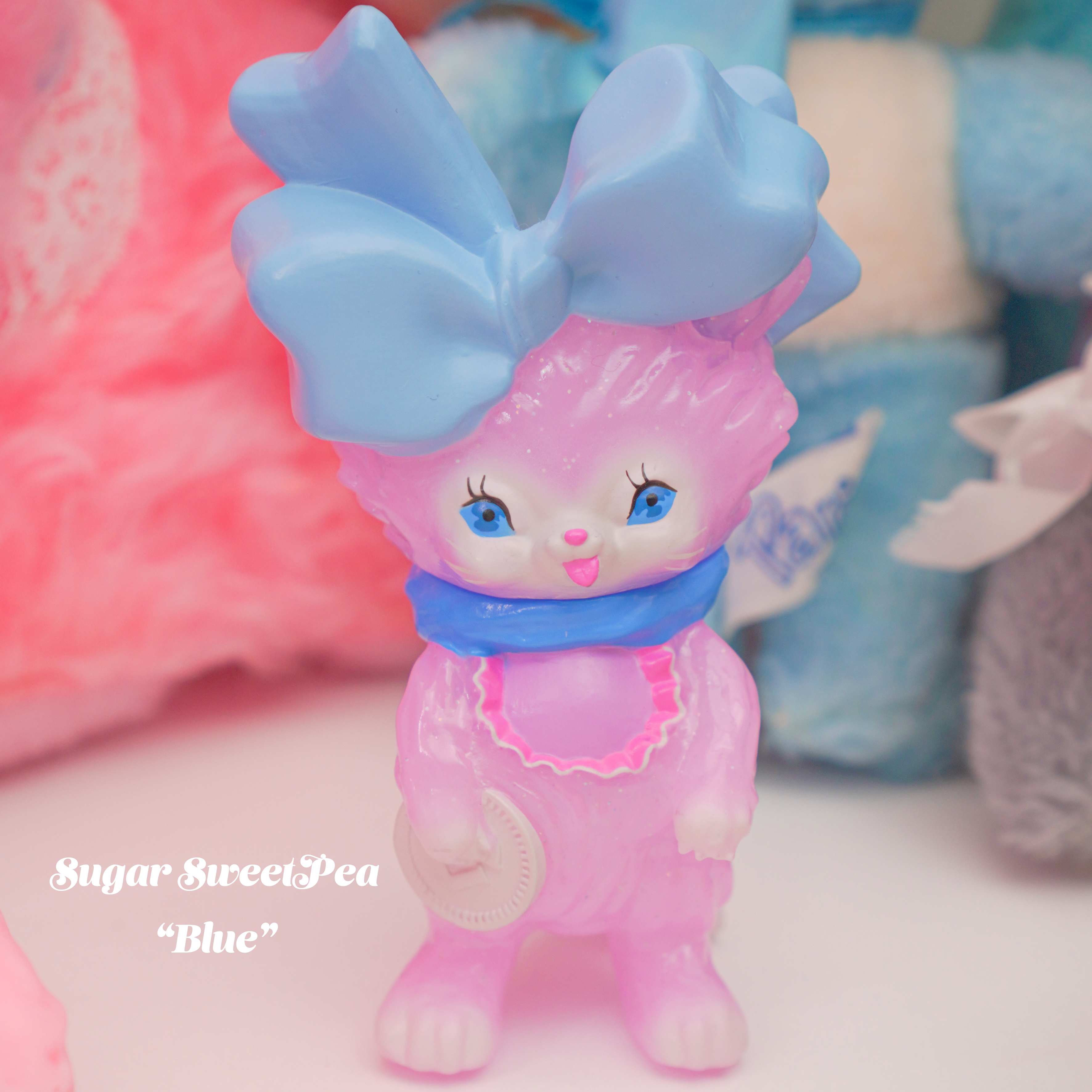 Bab Kat - Sugar Sweet Pea by Ms LUTRA, a 130mm Sofubi toy, features a cute bunny with a blue bow, perfect for collectors.
