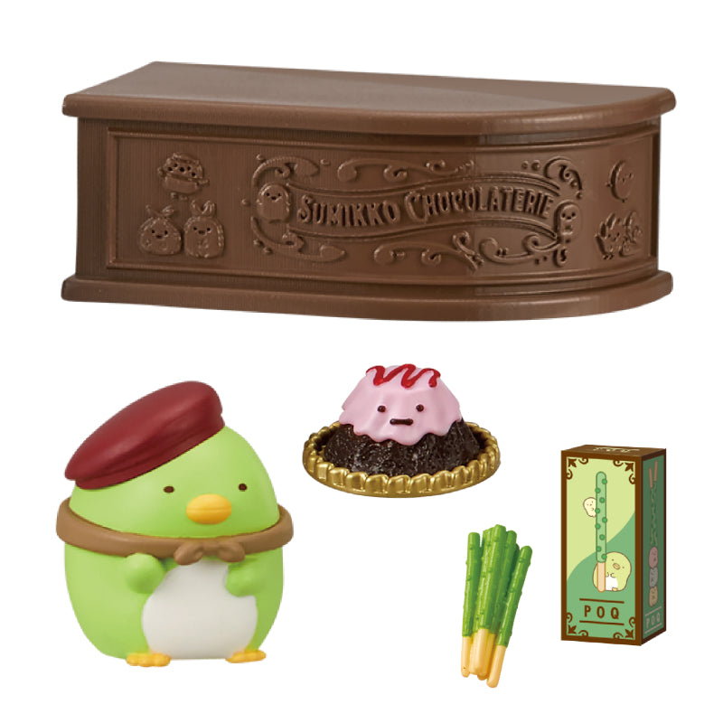 SUMIKKO CHOCOLATERIE Re-ment Blind Box Series featuring miniature chocolate shop set with Penguin? character, chocolate mound, biscuit sticks, and display façade.