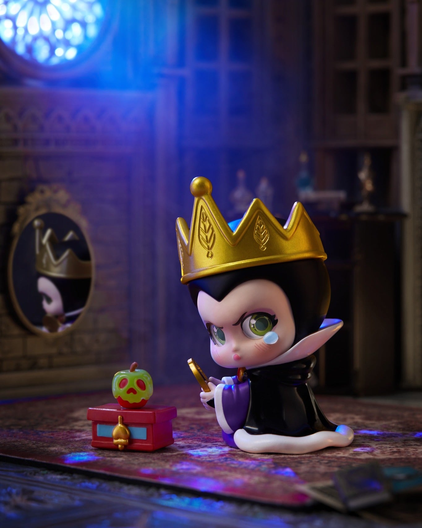 Chibi-style evil queen figurine from Disney Villains Born Rebellious Series, holding a mirror, beside a treasure box with poison apple, available for preorder.