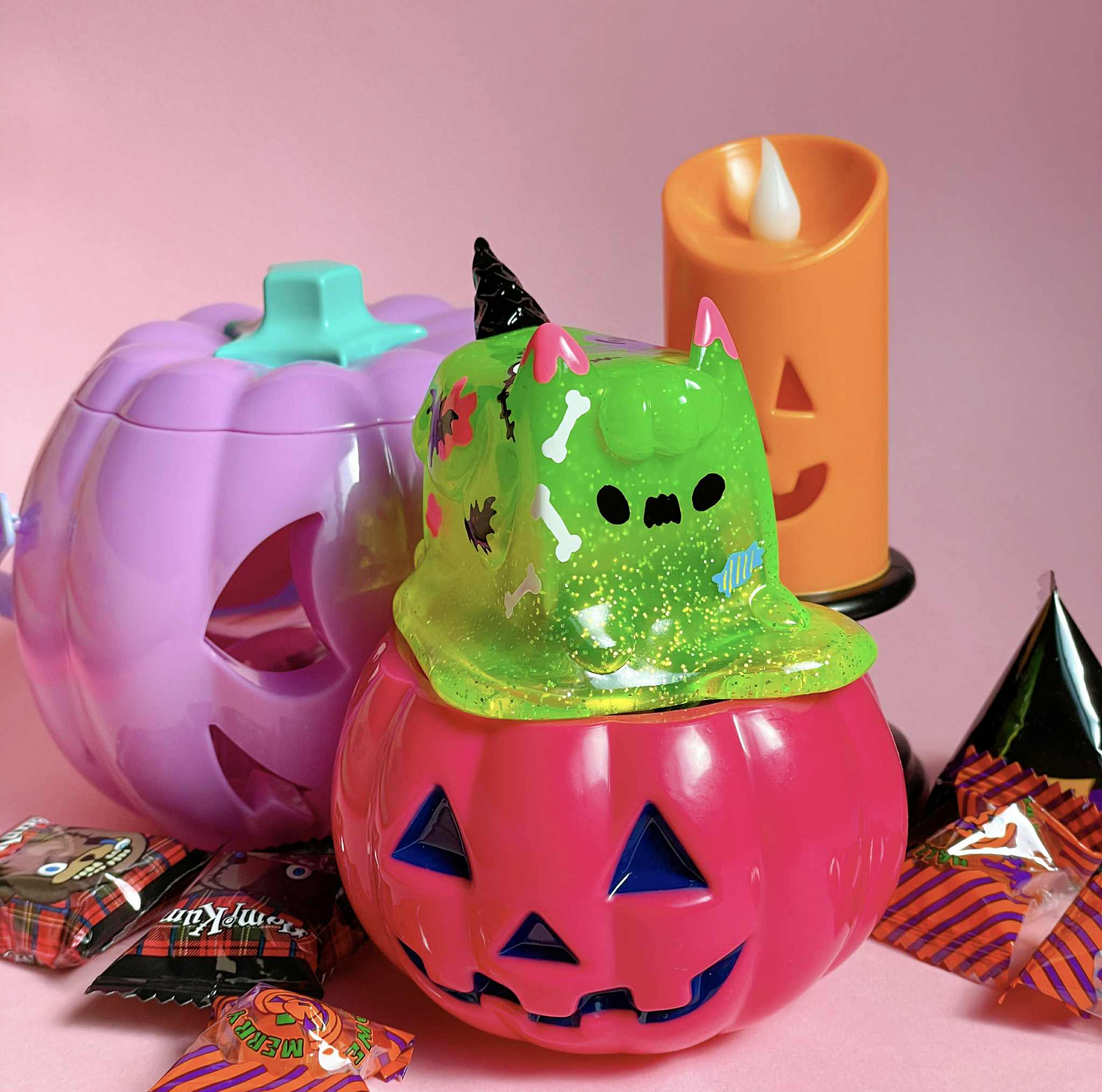Halloween Ice Cream Cat by Rato Kim - Preorder: A neon-green slime cat figurine on a pink jack-o'-lantern, surrounded by pastel pumpkins and candies.