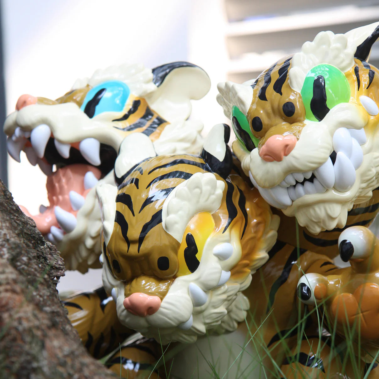 Three Headed Fierce Tiger Koshow by Grape Brain, 35cm vinyl collectible, featuring stylized tiger figures with vibrant eyes and exaggerated fangs, displayed outdoors.