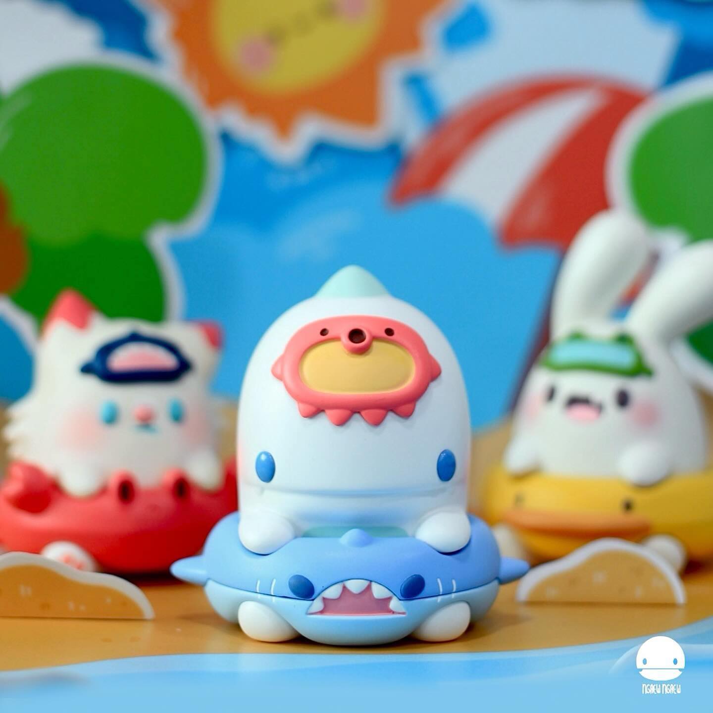 Ngeaw swimming shark figure with tiny character on back, part of a beach diorama with limited edition resin toys, highlighting Strangecat Toys’ unique art collection.