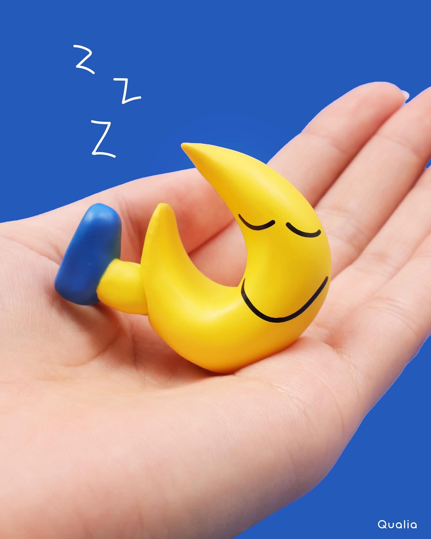 DAISUKE KONDO Art Collection Mascot figure 2 Gacha Series: A yellow moon figurine with closed eyes and a blue boot, held in hand.