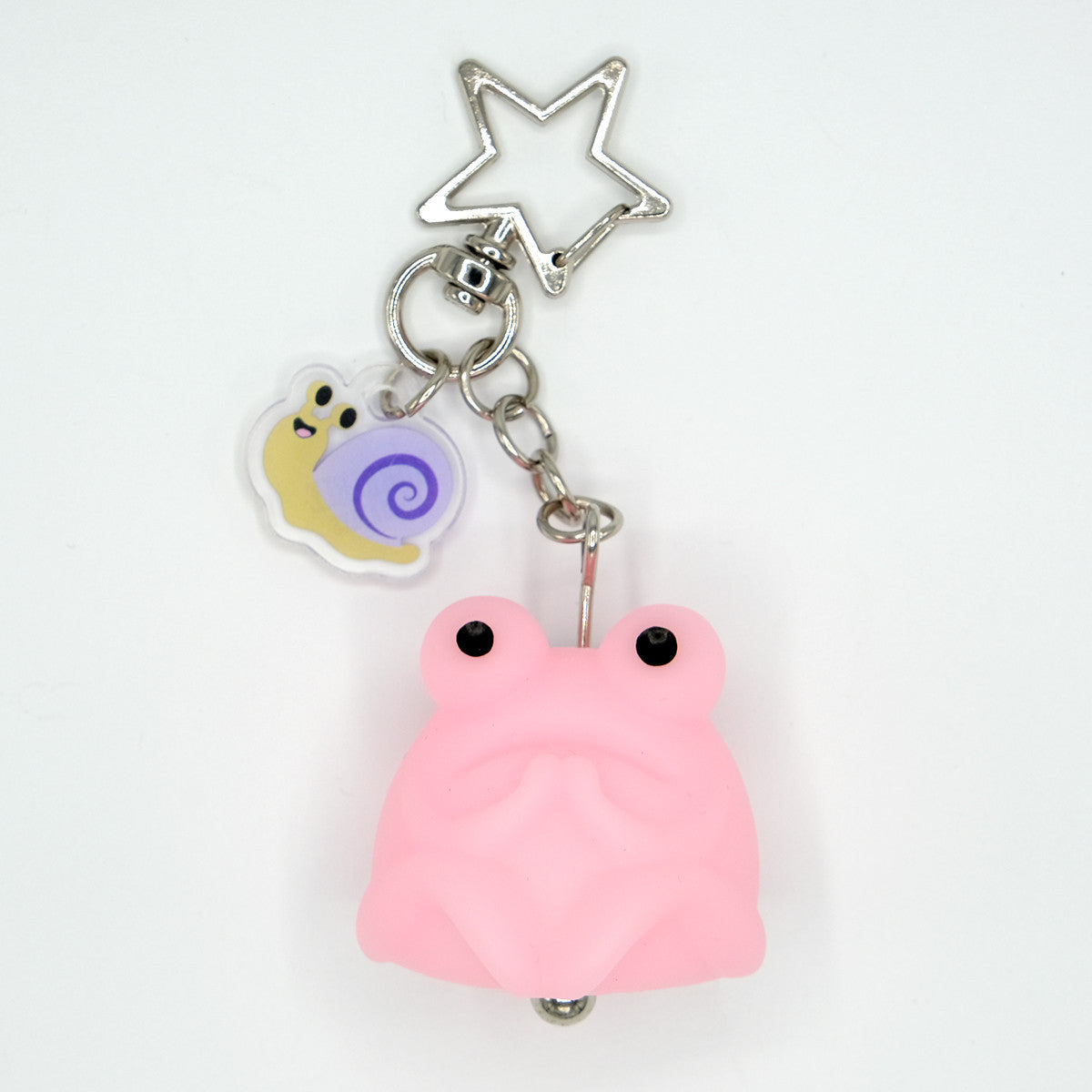 Fruggie the Toad Bag & Key Charm by Horrible Adorables features a glow-in-the-dark pink toad with a smiling snail charm and a stylish star-shaped clasp.