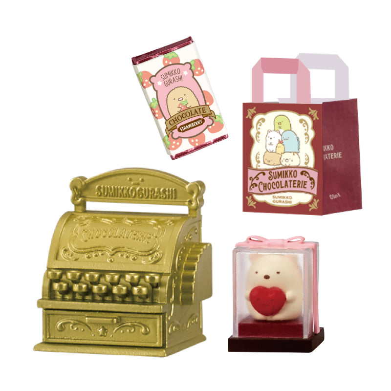 SUMIKKO CHOCOLATERIE Re-ment Blind Box Series featuring miniatures: strawberry-chocolate wrapper, branded bag, gold-tone cash register, and heart-holding Shirokuma in display.