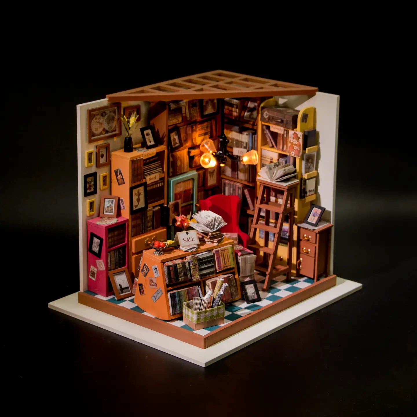 A miniature room with a lamp, bookshelves, a box of papers, and a ladder, embodying Sam's Study Rolife Library DIY Miniature Dollhouse from Strangecat Toys.