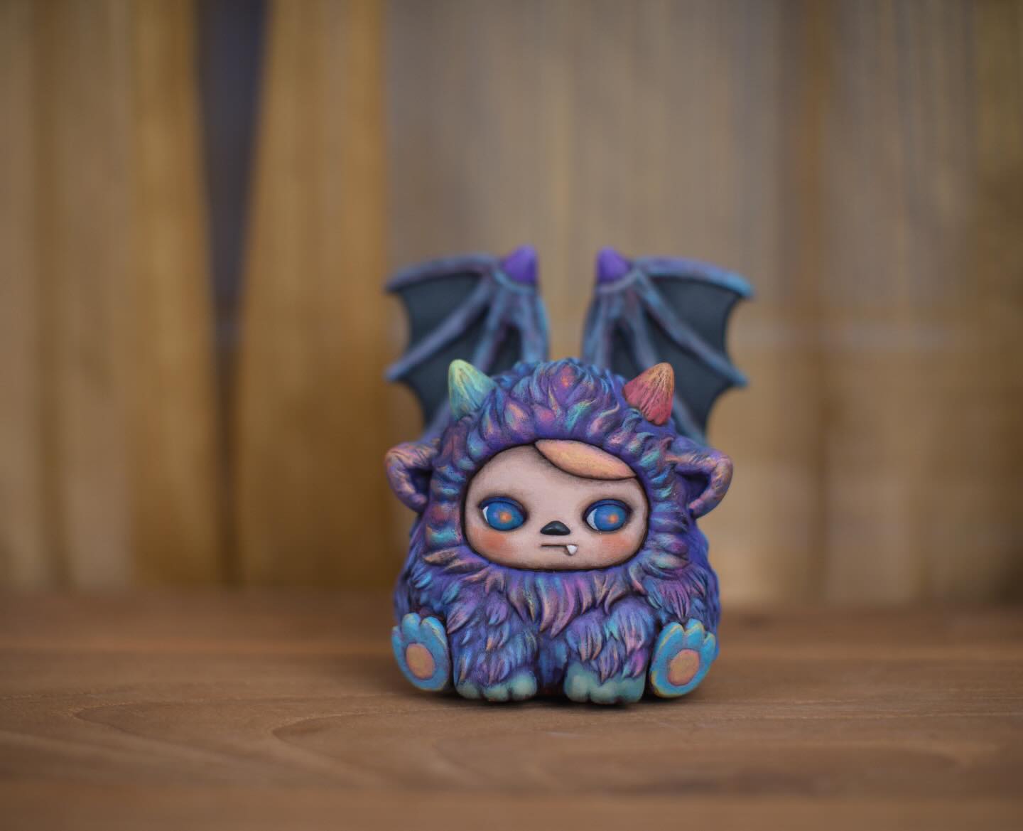 ZuZu Monster by Pucky: a hand-painted figurine featuring a furry creature with rainbow horns, bat wings, oversized paws, and an edition card.