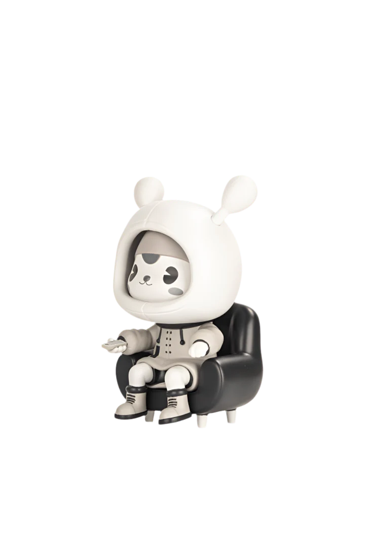 Napa - Retro figurine in a hooded suit with rabbit ears, seated in a black armchair, holding a gadget. Limited-edition art toy from Strangecat Toys.