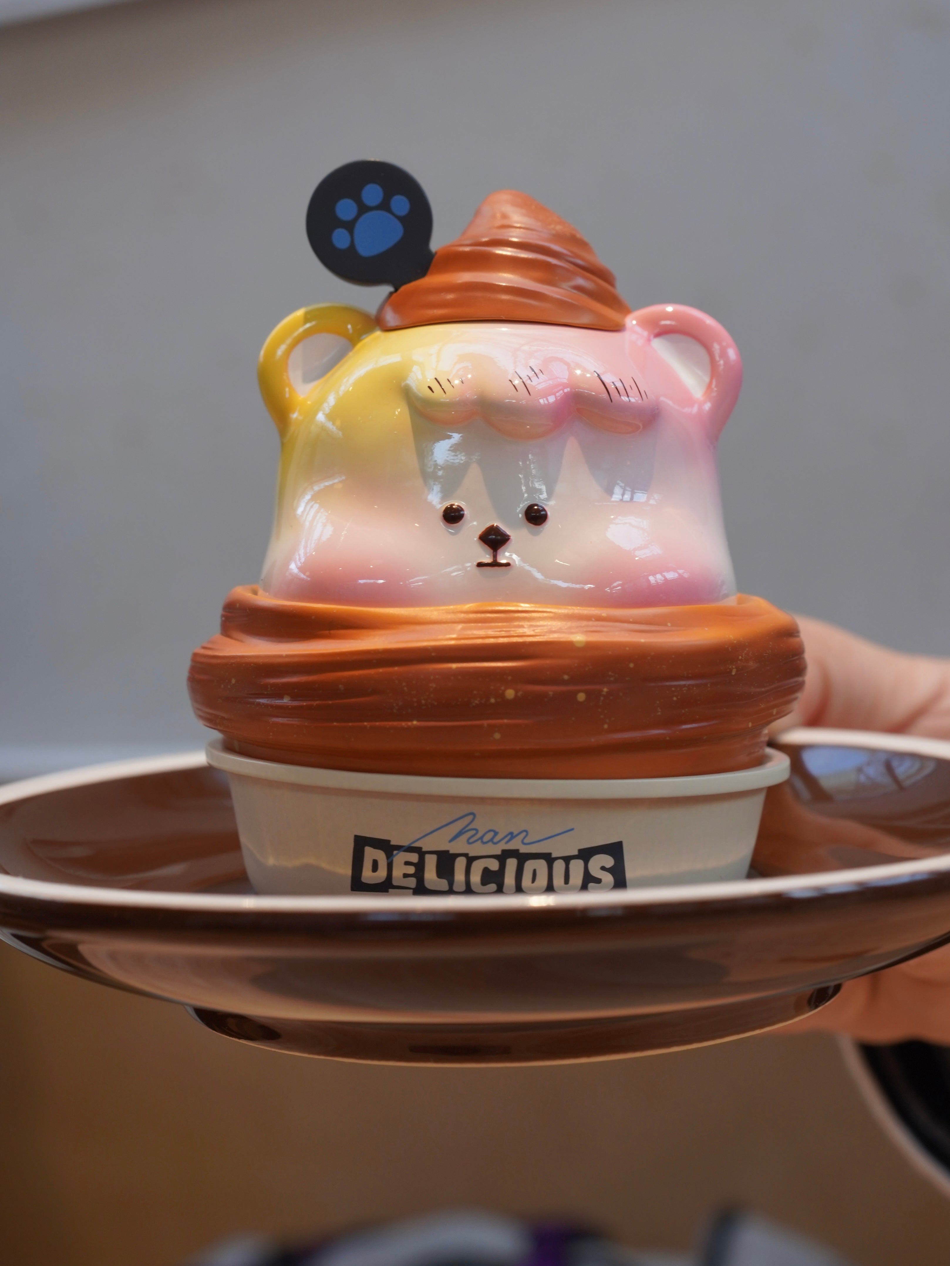 Croissant Han Han toy on plate with dessert items and paw print detail.