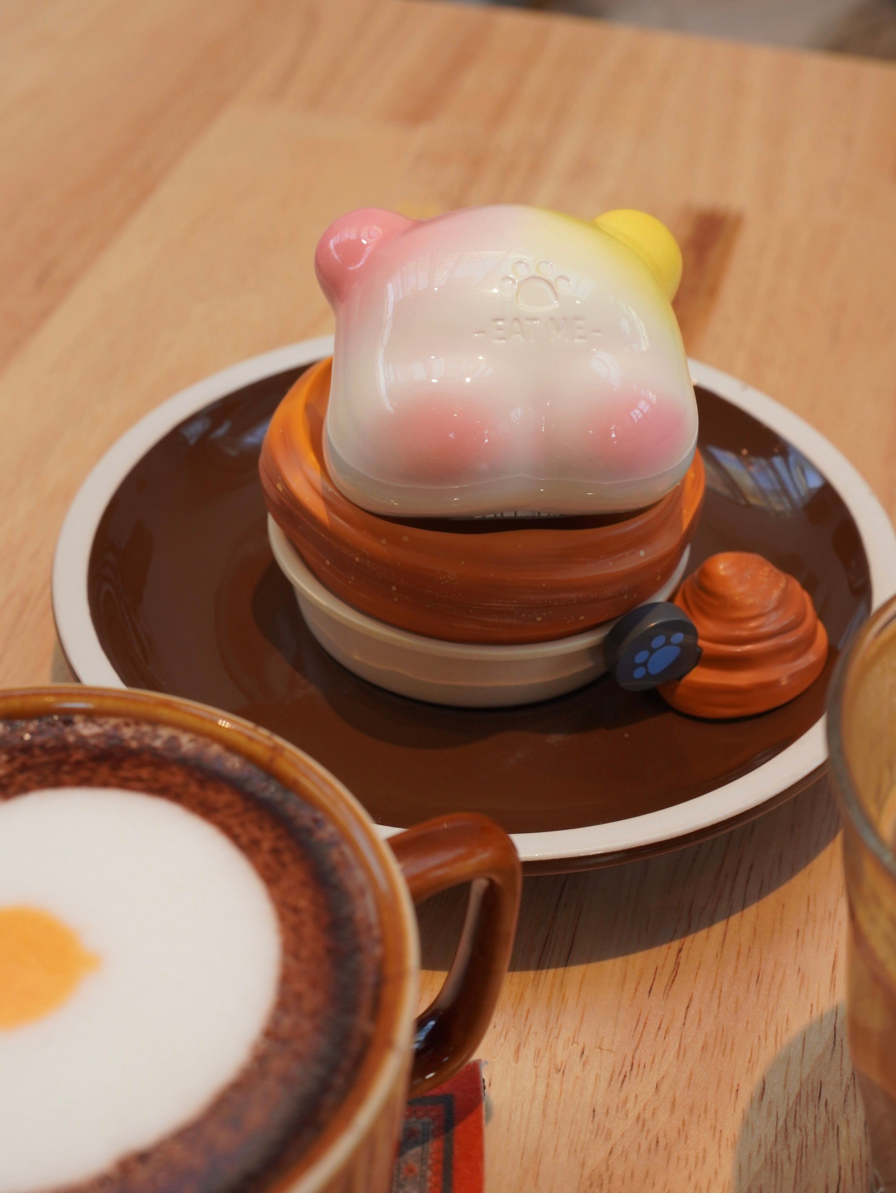 Croissant Han Han figurine on plate with coffee cup, piggy bank, and more.
