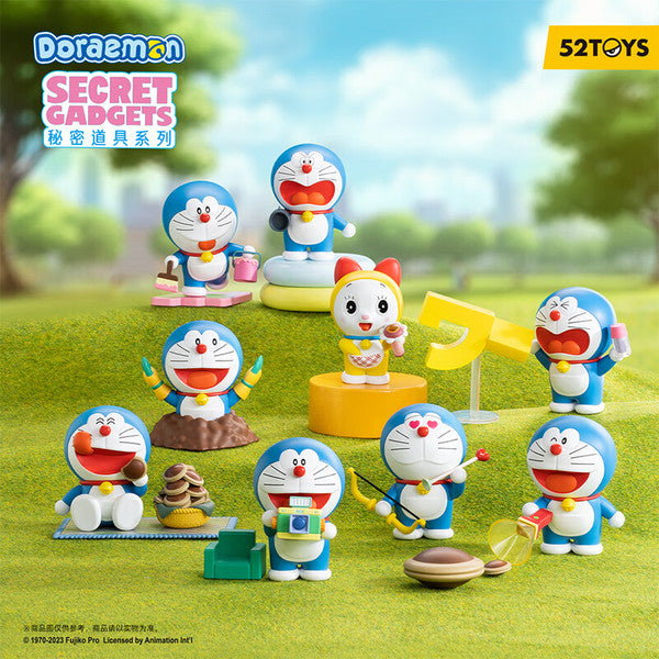 Cartoon toys on grass, cupcake in basket, toy figure, and characters with camera in Doraemon Secret Gadget Blind Box Series.