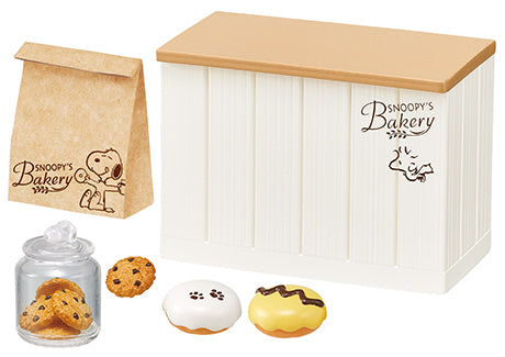 SNOOPY'S BAKERY Re-ment Blind Box Series featuring toy bakery items, including cookies and a doughnut with paw prints, packaged in a themed box and bag.