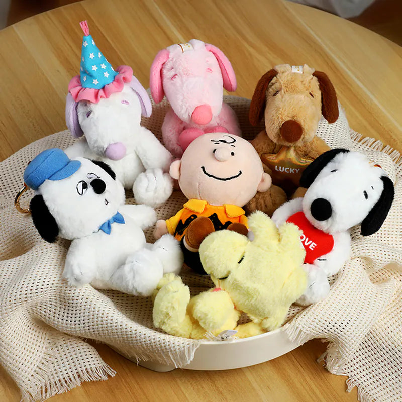 VIPO x Peanuts Snoopy Cute Pals Series Blind Box - Plush Keychain assortment with Charlie Brown, Snoopy variations, Woodstock, and dog-themed plushies on a table display.