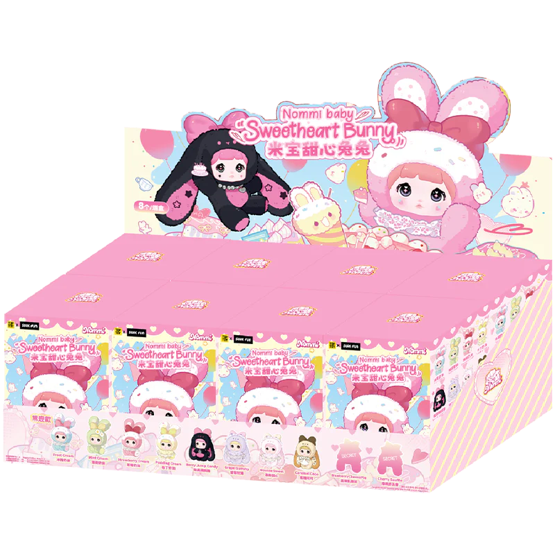 Nommi Baby Sweetheart Bunny Plush Blind Boxes displayed, featuring dessert-themed bunny figurines in a pink countertop display, available for preorder at Strangecat Toys.