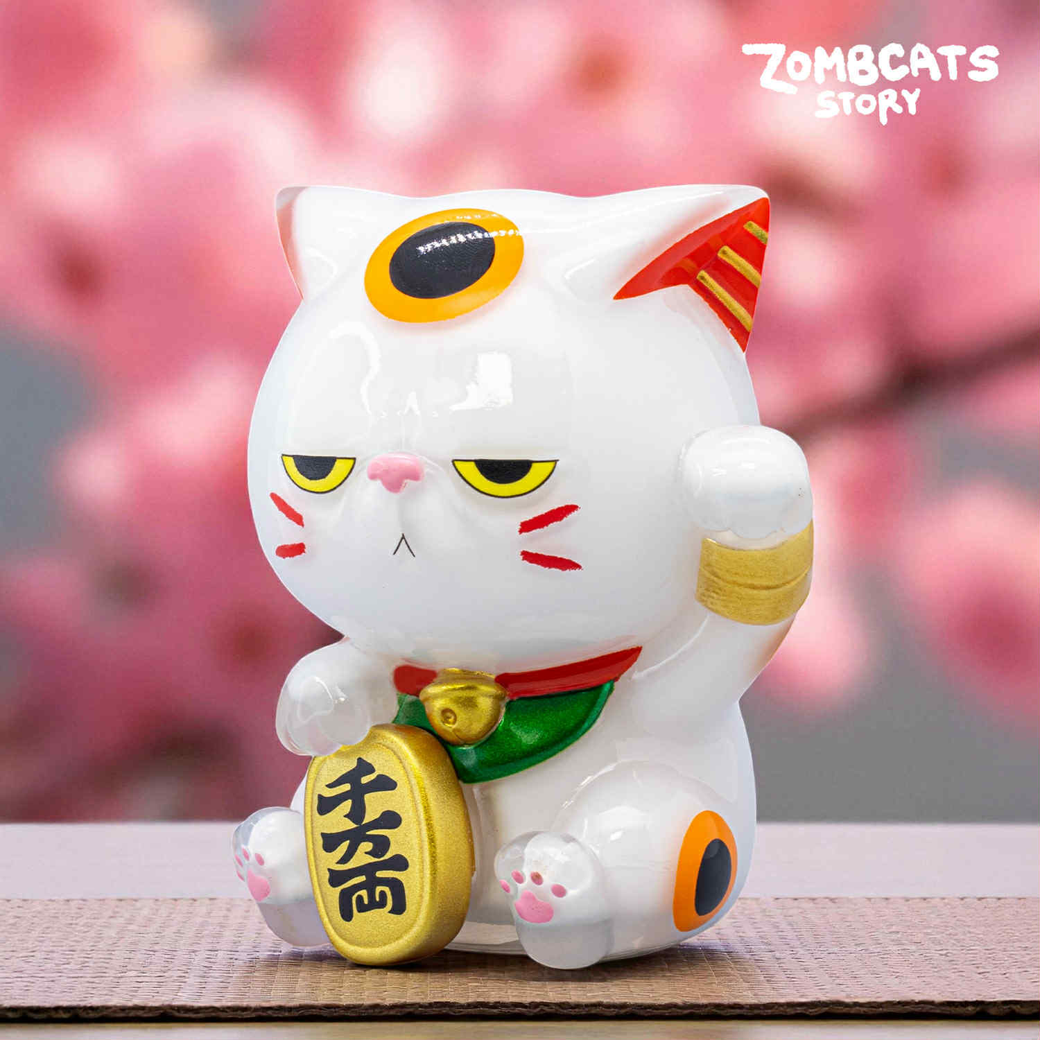 Zombcats Story - Grumpy Maneki LOTTERY figurine features a glossy, zombie-style lucky cat with half-lidded eyes, a bell collar, and a gold coin.