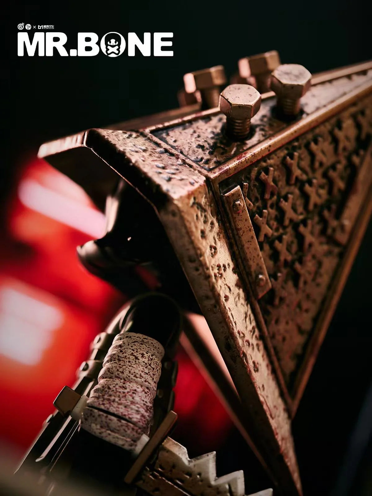 Mr. Bone - Pyramid Head 200% - Preorder: Close-up of a spattered metal helmet with bolts, iconic horror collectible, limited edition of 300.