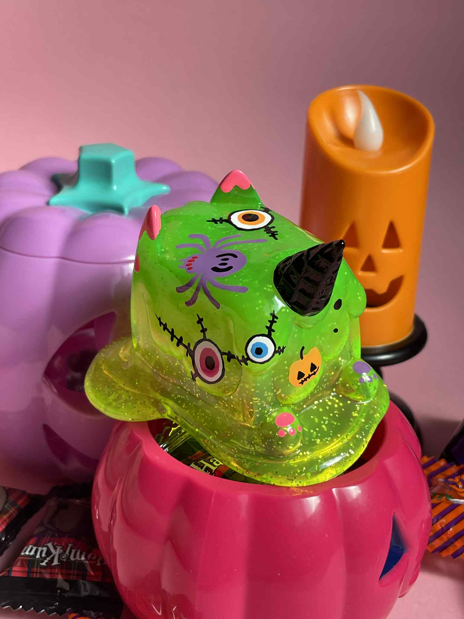 Halloween Ice Cream Cat by Rato Kim - Preorder: A neon-green monster toy in a pink pumpkin bucket, surrounded by Halloween-themed decor.