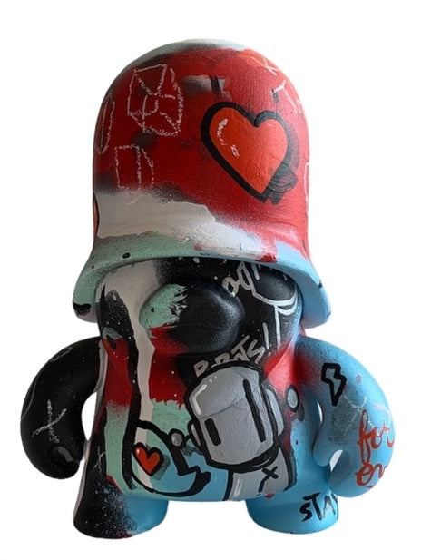 Close-up of a toy with graffiti, helmet, and cartoon features - Bear With Me For a Moment by Chris RWK, 6 LEGO art toy.