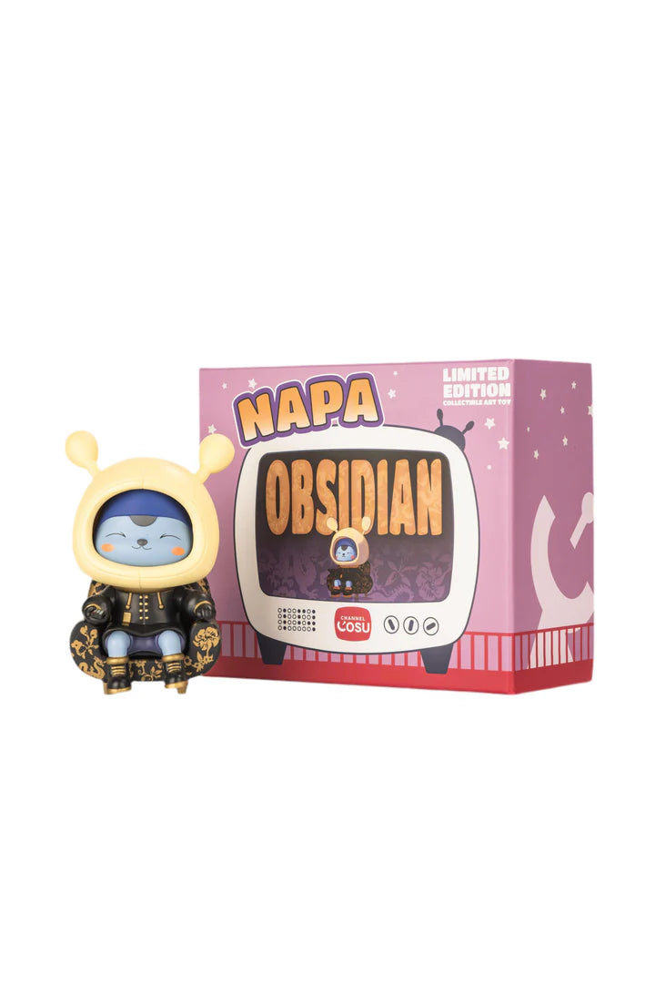 Napa - Obsidian vinyl art toy featuring a blue-faced alien in a yellow hooded coat, beside its retro TV-style packaging, marked Limited Edition.