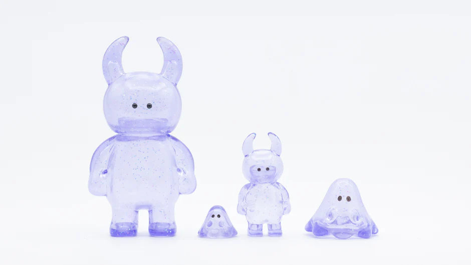 Set of four UAMOU CLEAR LAVENDER GLITTER figures, featuring minimalist, kawaii-inspired designs in translucent purple with glitter specks, made from soft vinyl in Japan.