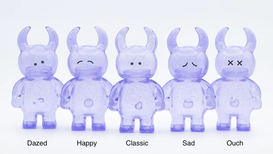 Five UAMOU CLEAR LAVENDER GLITTER vinyl figures with unique expressions: Dazed, Happy, Classic, Sad, Ouch; 7cm tall, made in Japan.