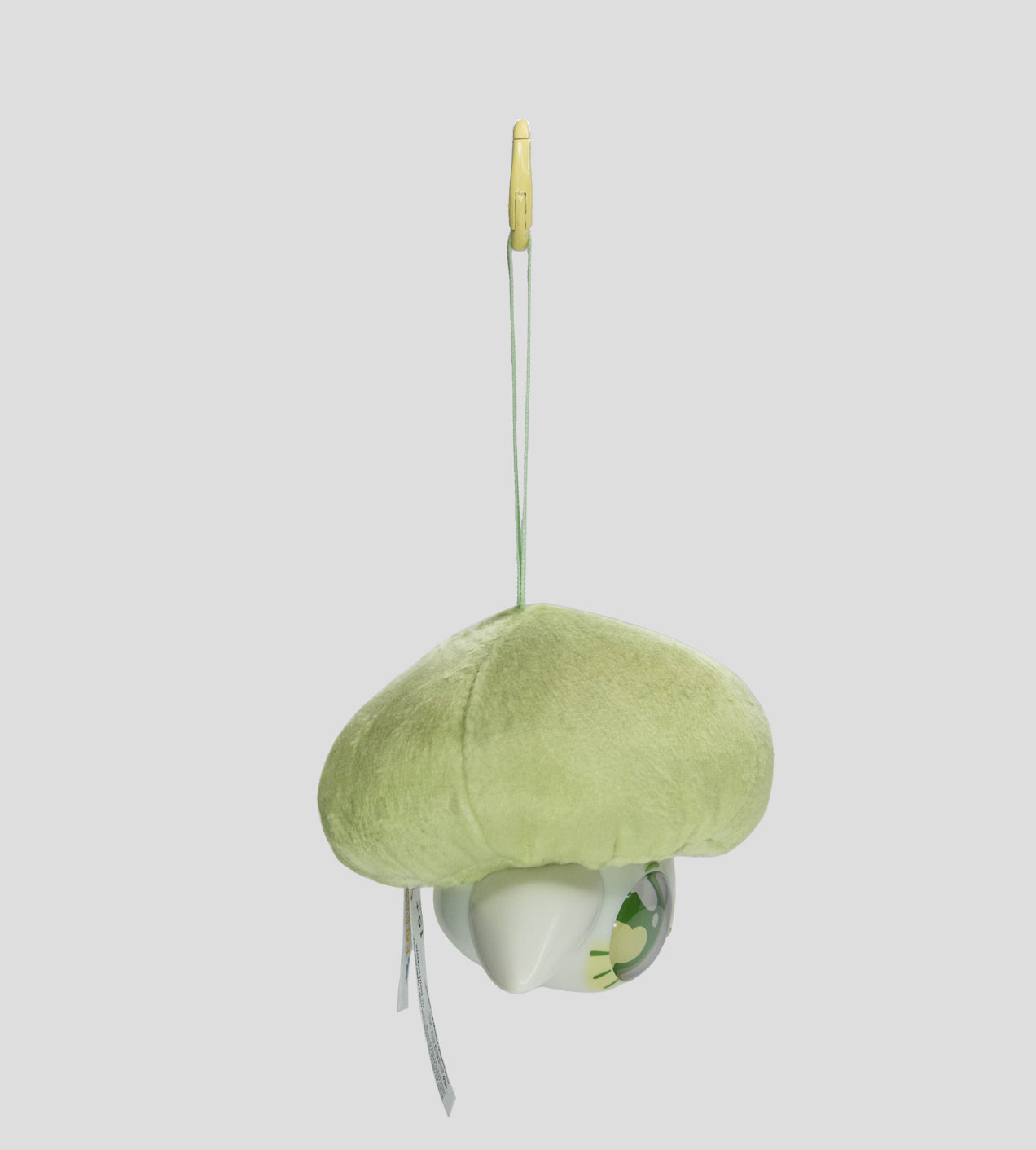 Capkins - Plush Bag Clip featuring a white owl-like character with green-yellow designs, suspended from a fuzzy green cushion and yellow clip.