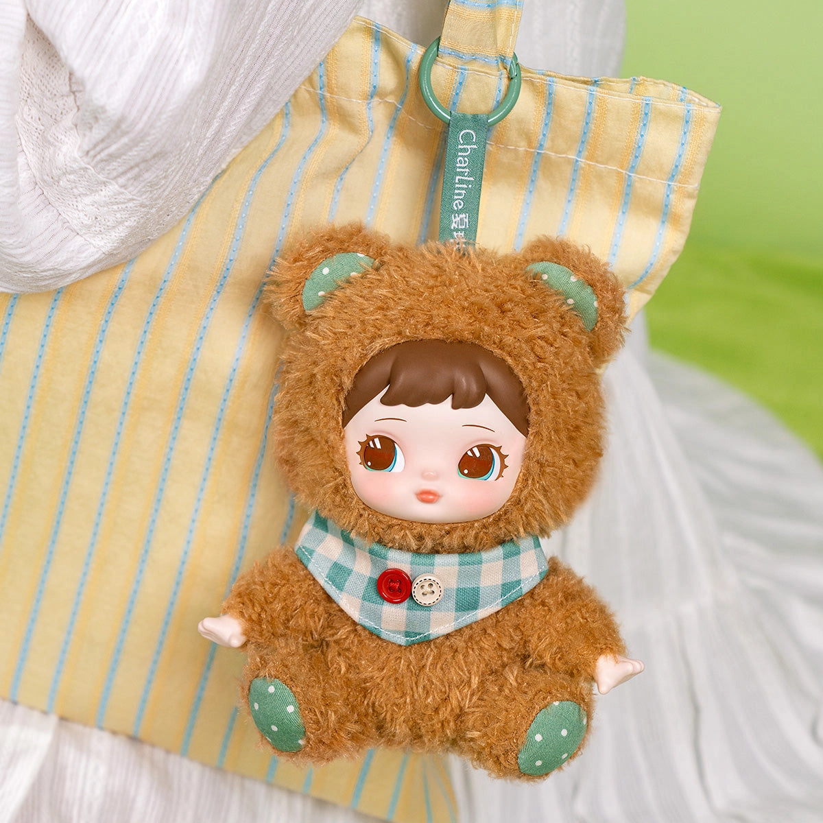 Rolife Surprise Plush Pendant - Charline's Forest Hide&Seek MXAXX: A bear-suited doll keychain with a neckerchief, attached to a striped tote bag. Perfect for cute, magical adventures.