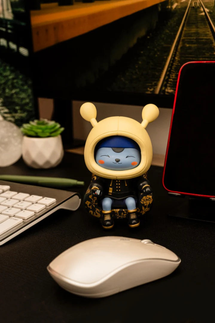 Napa - Obsidian figurine seated with a matching chair, holding an object, part of Strangecat Toys' limited edition art toy series.