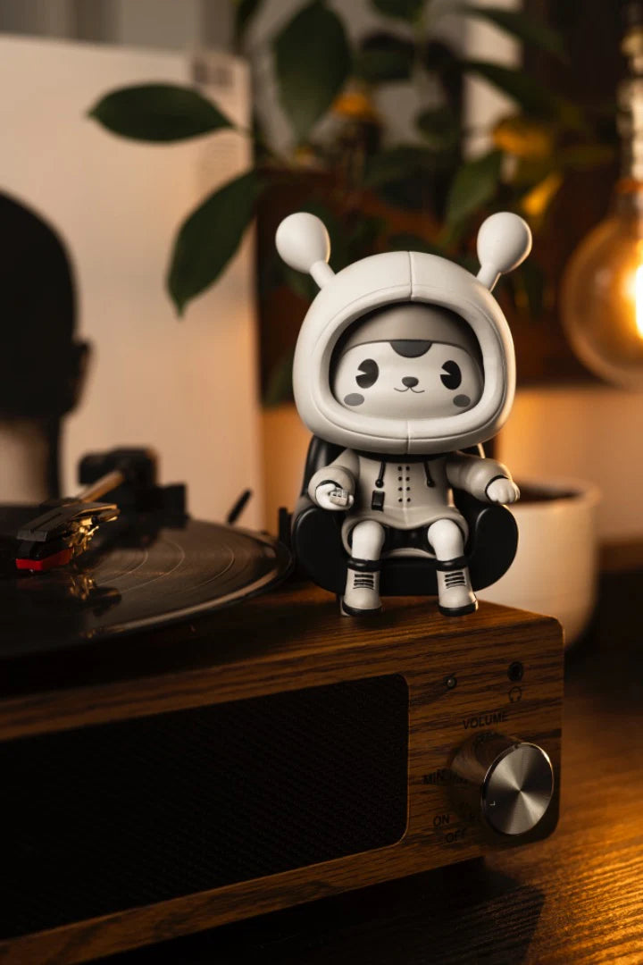 Napa - Retro vinyl art-toy on a wooden turntable, seated in a tiny chair, captures classic animation style with a hoodie and antennae.