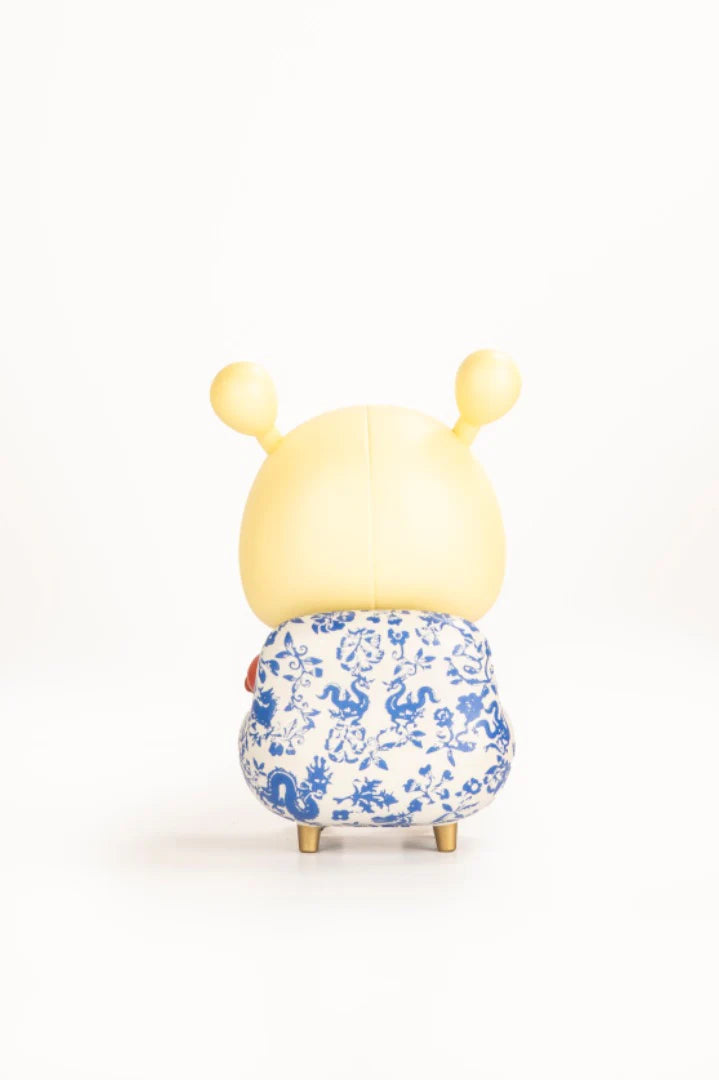 Napa - Porcelain edition figurine, featuring a yellow head with antennae, blue-and-white porcelain design, and golden feet, against a white background.