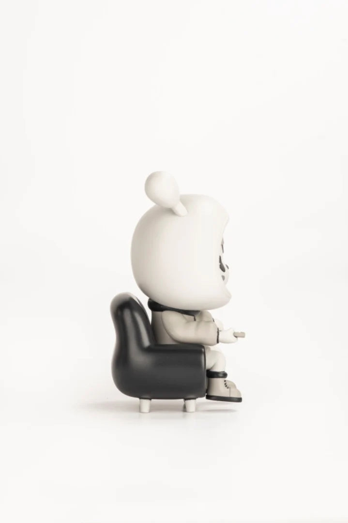 Napa - Retro vinyl figure on a black chair, white with mask-like face, part of a limited series by Strangecat Toys.