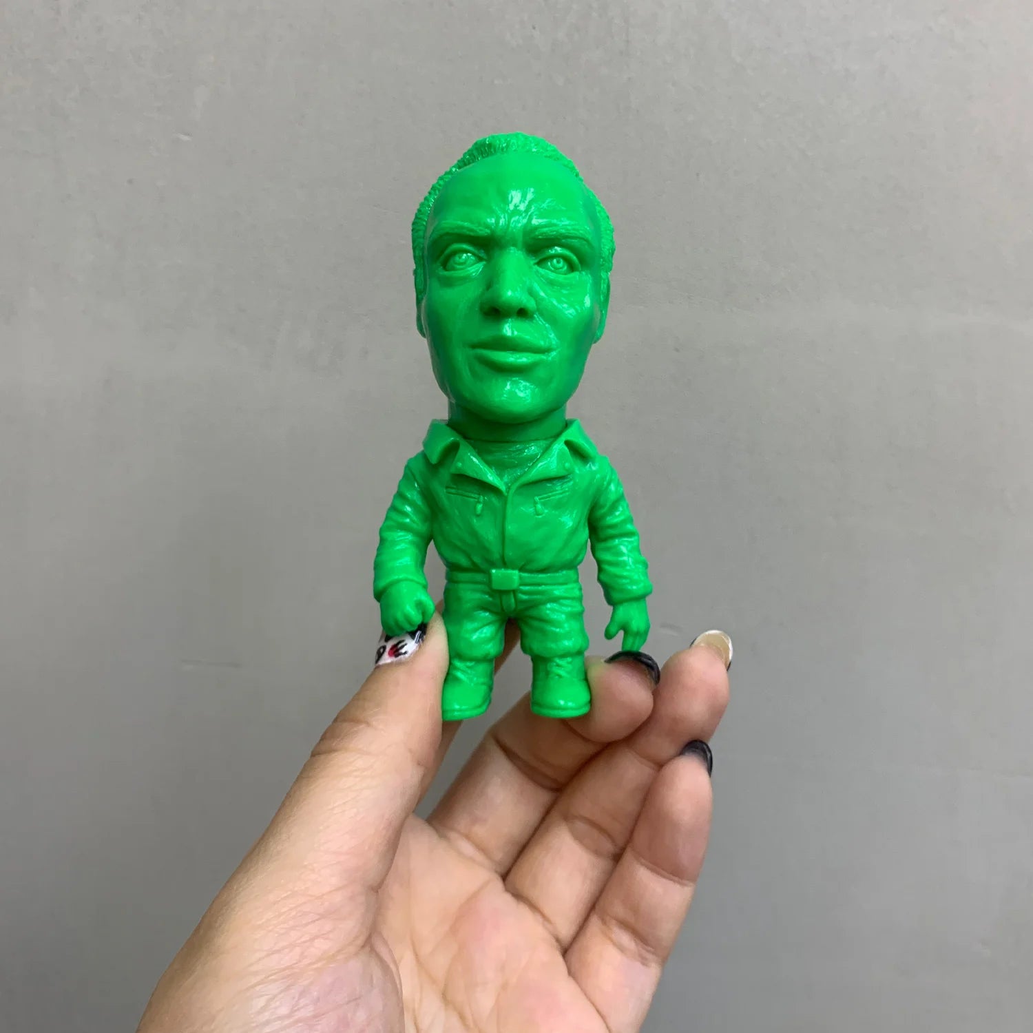 ZOMBI: DAWN OF THE DEAD Who Goes There Blind Box Series figurine, a stylized green vinyl character held between fingers with decorative nail art.