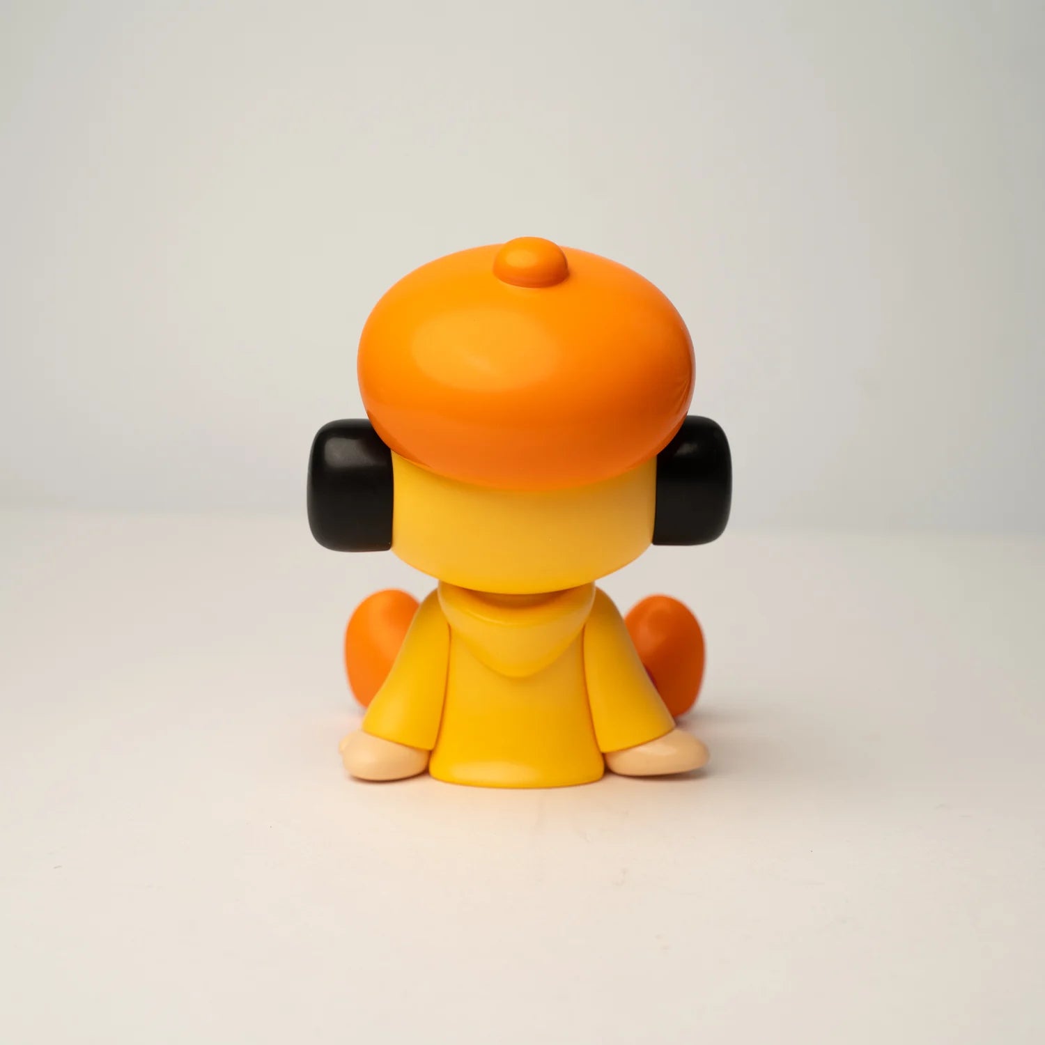 GREENIE OHIGEnoPON EDITION - Preorder vinyl figurine, back view, with orange beret, yellow hoodie, black ear pieces, and orange shoes.