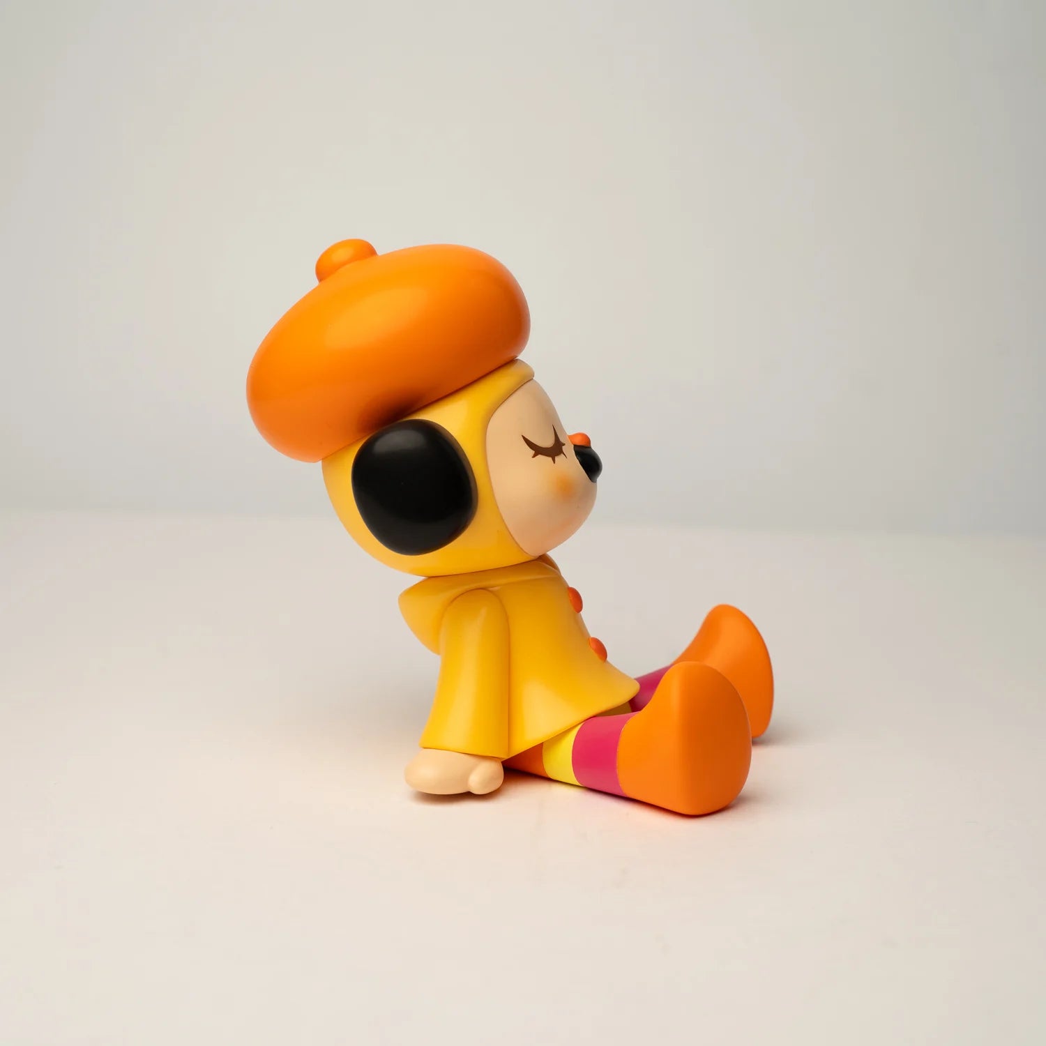GREENIE OHIGEnoPON EDITION - Preorder: Vinyl collectible figure with orange beret, yellow coat, and striped legs, designed by TOO NATTHAPONG, sitting on a white surface.