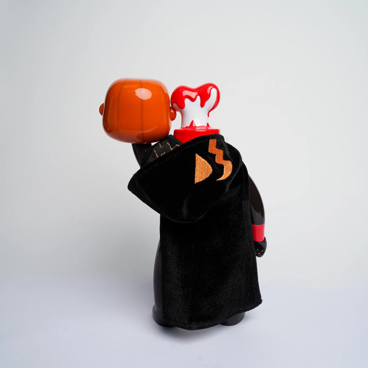 MR NOBODIES (HEADLESS HORSEMAN) - Preorder: Stylized vinyl art-toy with glossy black-red body, velvet cape, holding its head, featuring a macabre, Halloween-inspired design.