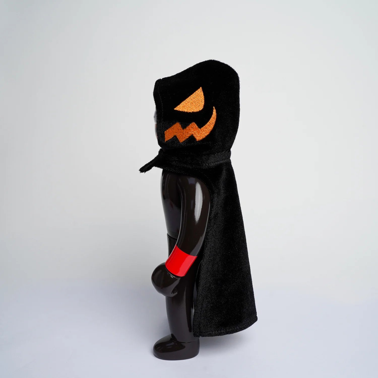 MR NOBODIES (HEADLESS HORSEMAN) art toy in glossy black vinyl, features a hooded cape with jack-o'-lantern details, and a red-banded wrist.