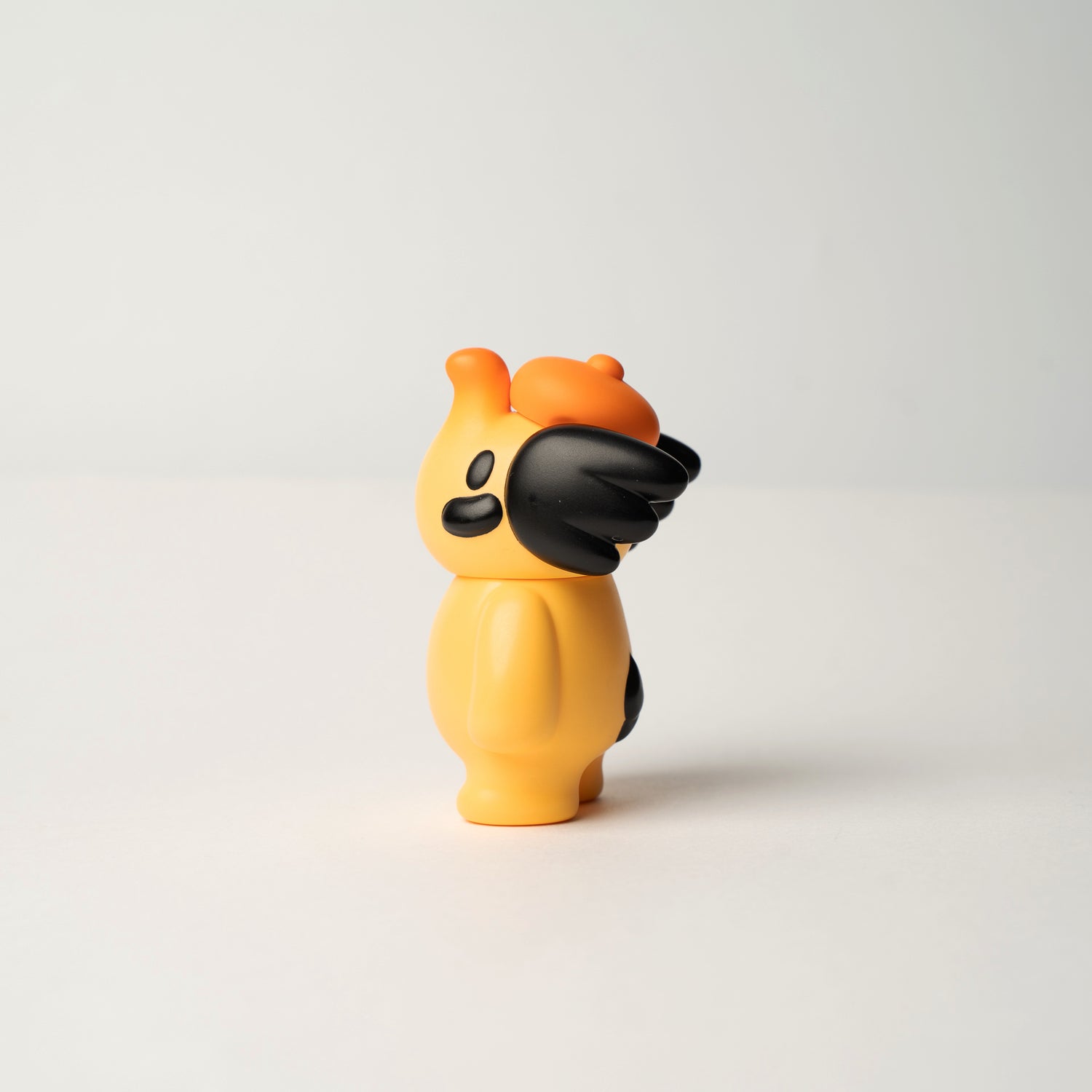 ELFIE HERE I AM! 100% OHIGEnoPON EDITION vinyl figure, warm yellow with black accents, featuring stubby horns and simple facial features, on a neutral background.