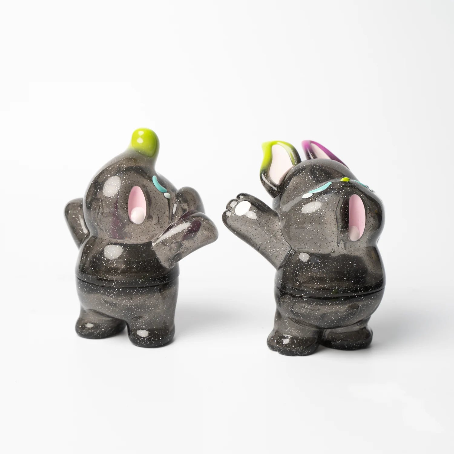 Alt text: ELFIE & NIMBUS YAWN GLITTER EDITION: Two small vinyl figurines of elephants in a printed box, available for preorder, shipping July 2024.