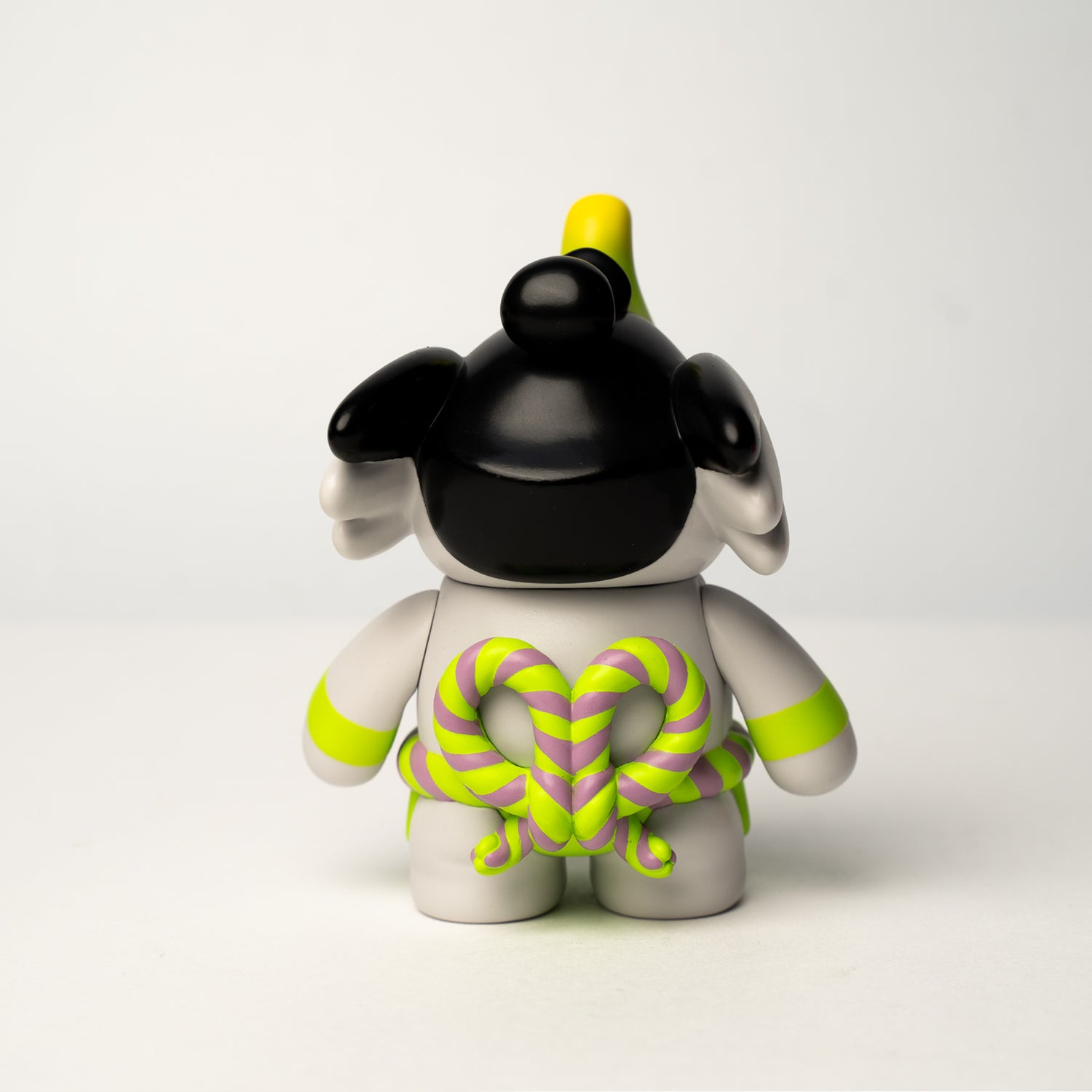 Traveller Elfie 'Sumo' Edition vinyl figurine showing back view with heart-shaped rope detail on smooth body, featuring neon-green accents. Preorder for June 2026.