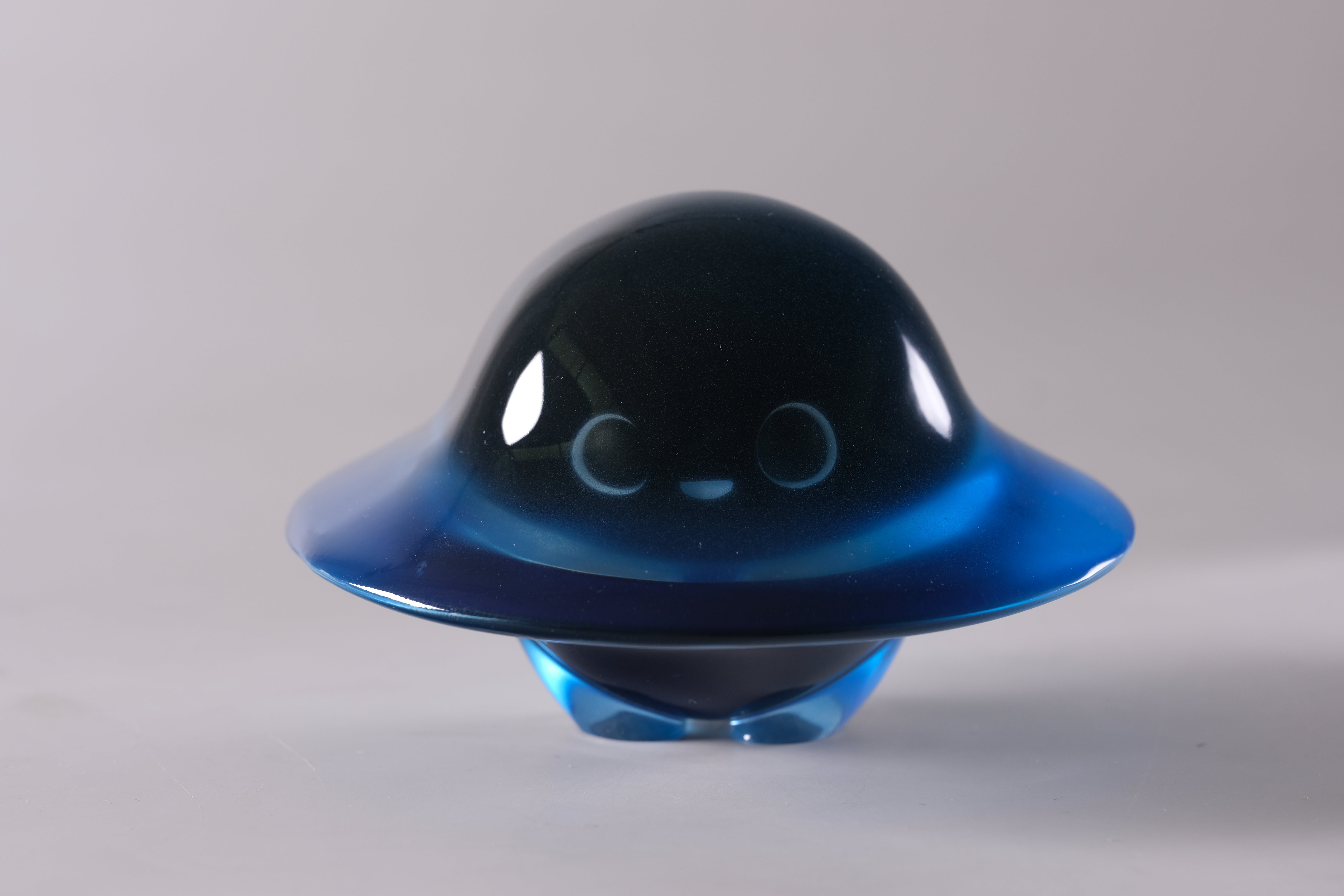 Glow in the Darkmite! by Yutoos: A glossy, cartoonish UFO-shaped resin figurine with a smiling face.