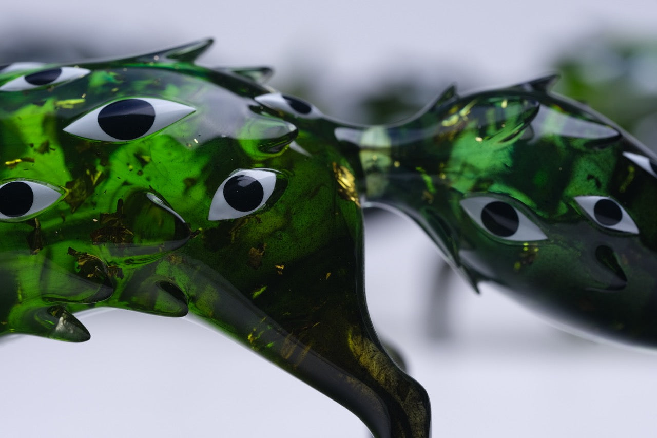 Bogwalker Oracle by Faunwood: A glossy, emerald-green resin sculpture with eye motifs, featuring unique organic contours. Limited edition of 100, 10cm tall.