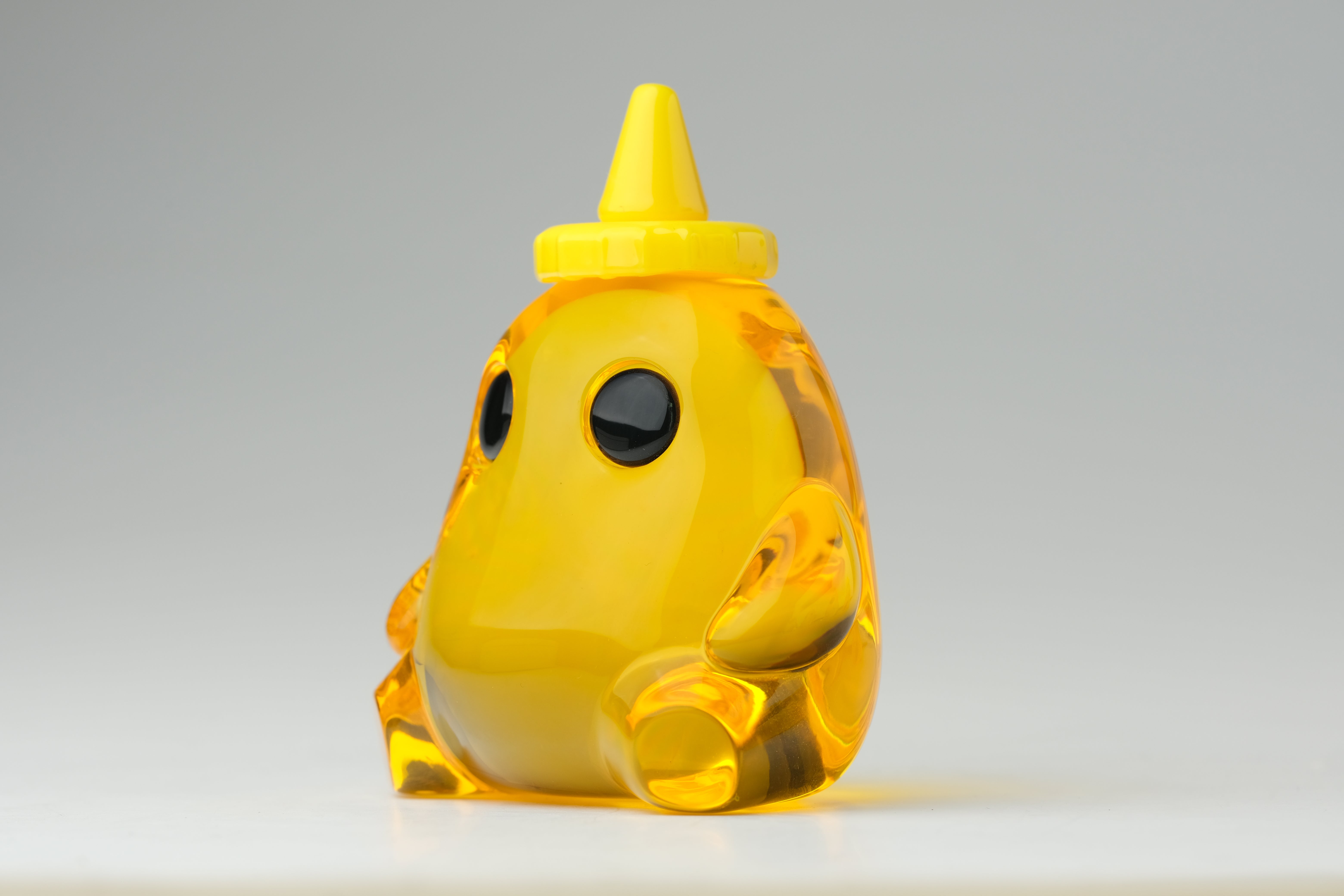 Honey Stubby by The Lostlings, a 3.5 resin toy with a unique yellow cone shape, limited to an edition of 50, displayed up close.