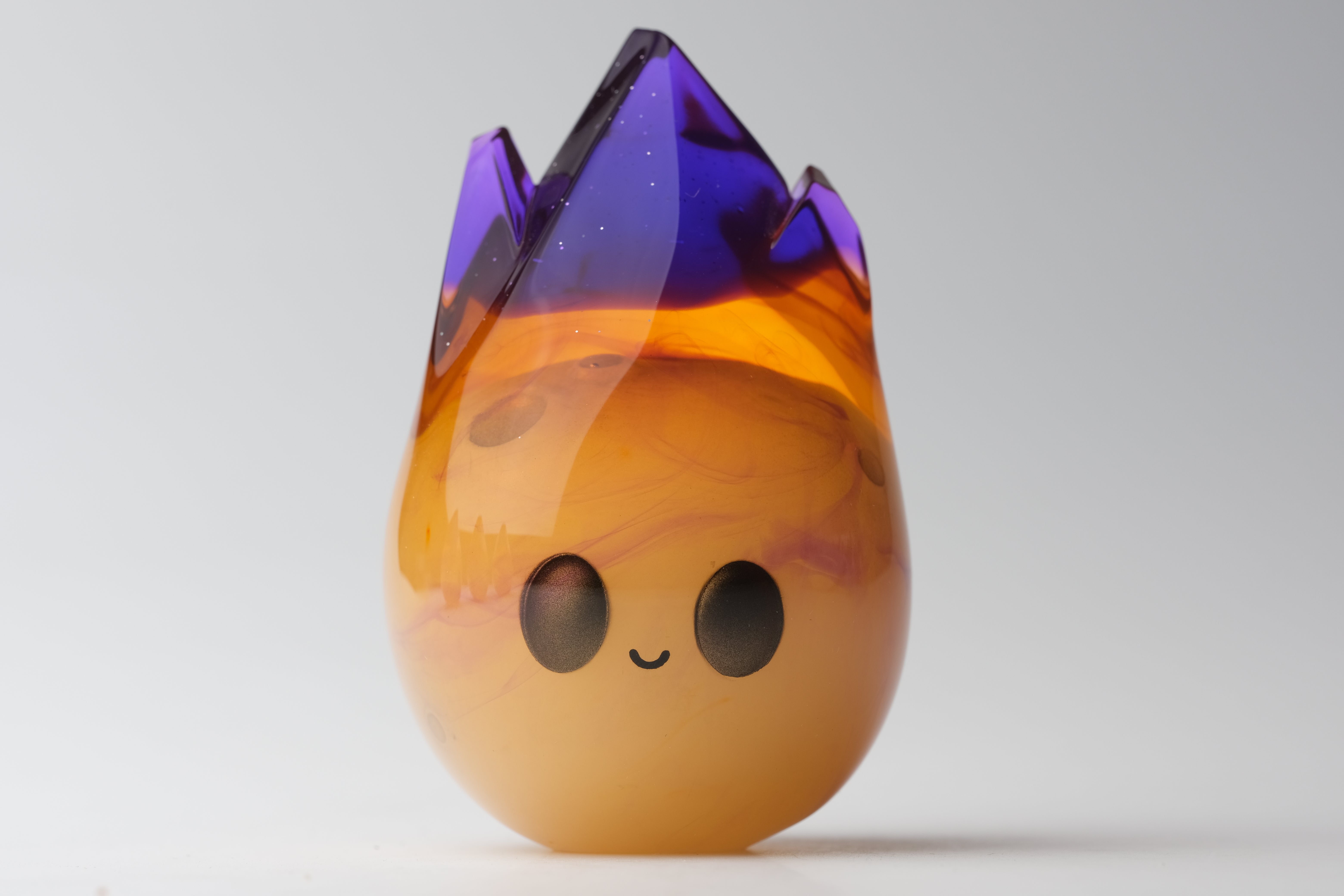 Cosmite by Yutoos, a 3.5 resin art toy, edition of 50, featured against a yellow backdrop, showcasing its sleek, black oval form.