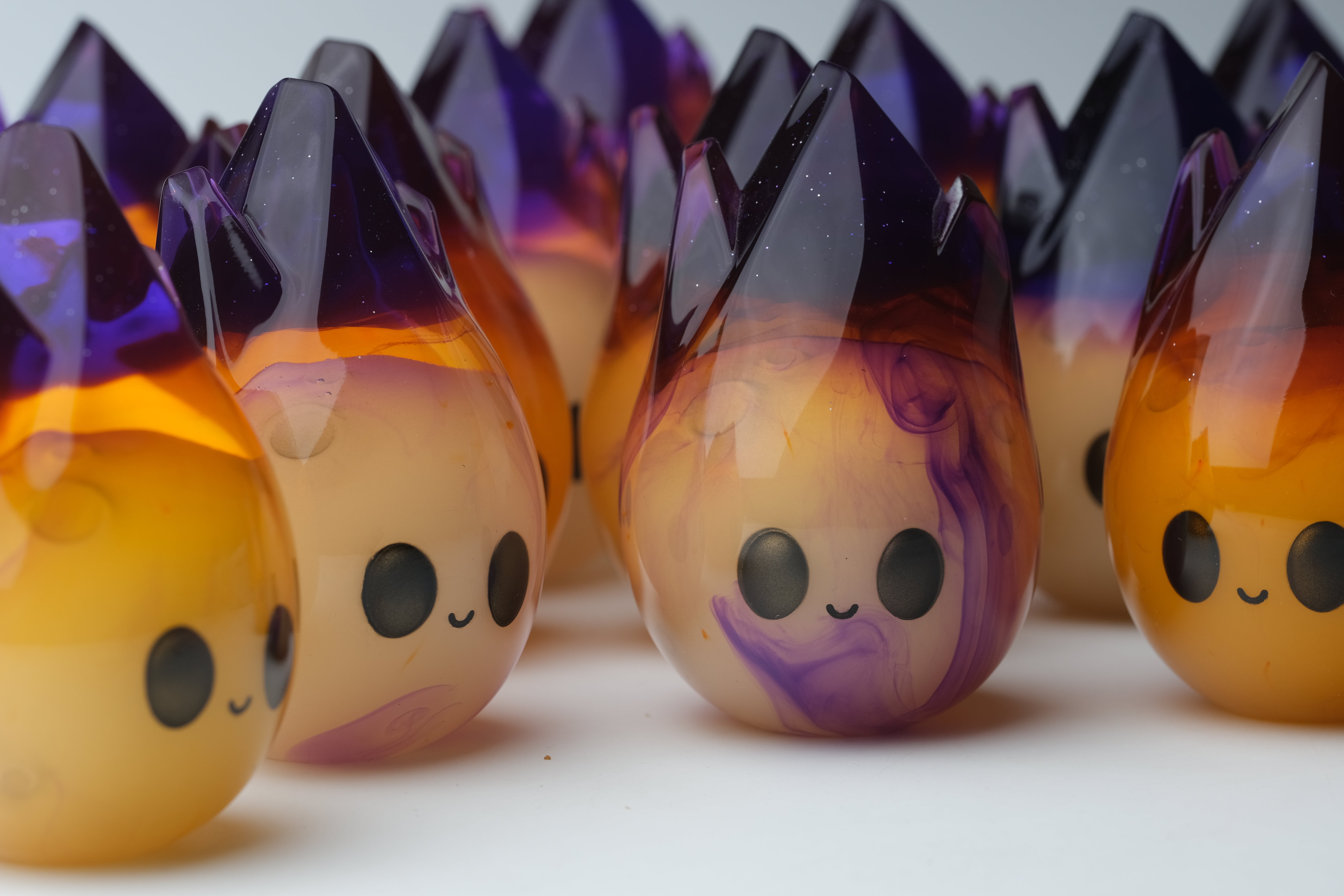 Cosmite by Yutoos, a 3.5 black oval resin object, limited edition of 50, showcased on a white surface, highlighting its unique artistic design.