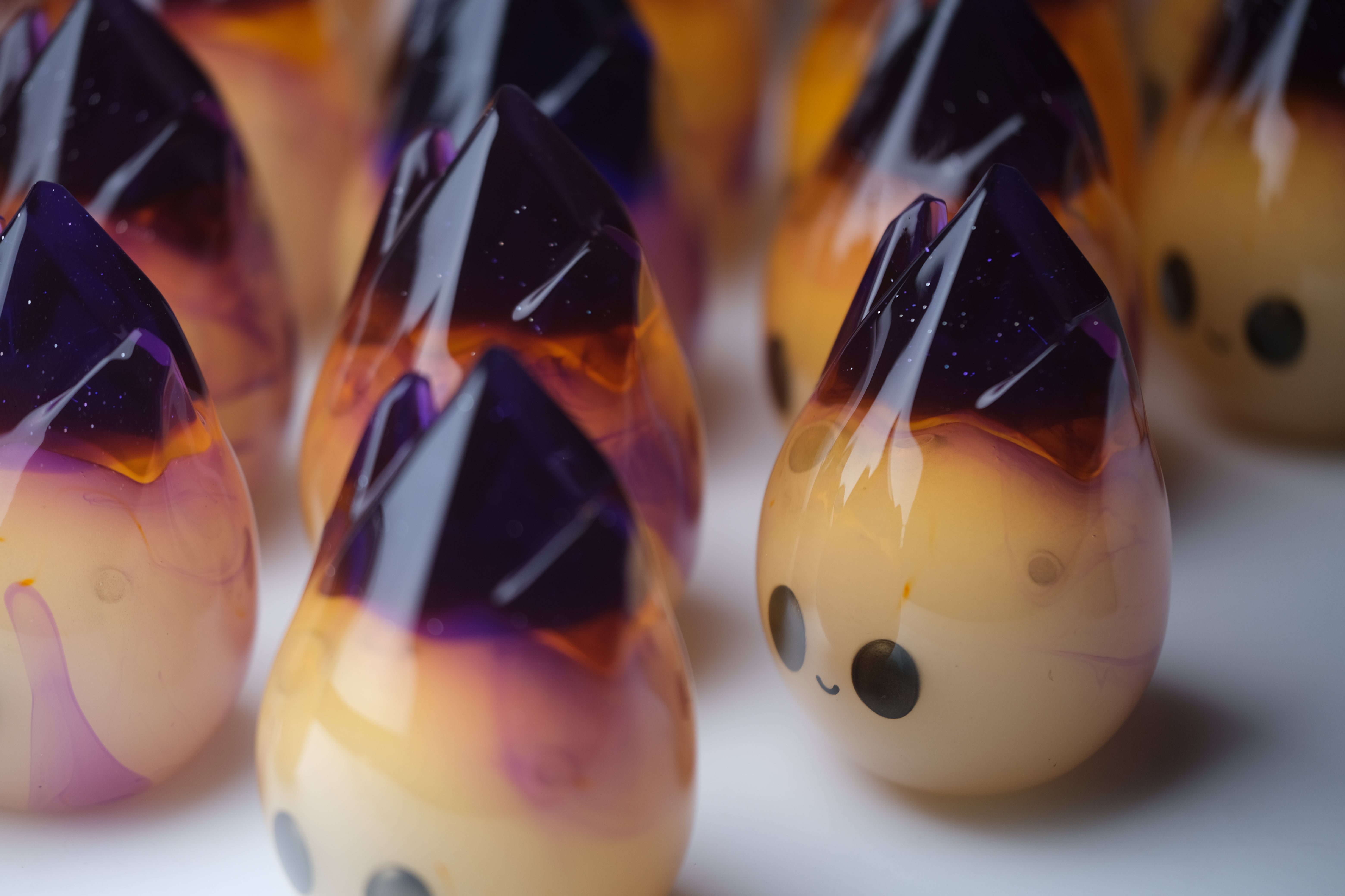 Cosmite by Yutoos, a 3.5 resin art toy from an edition of 50, featuring a blurred guitar and glass object in the background.