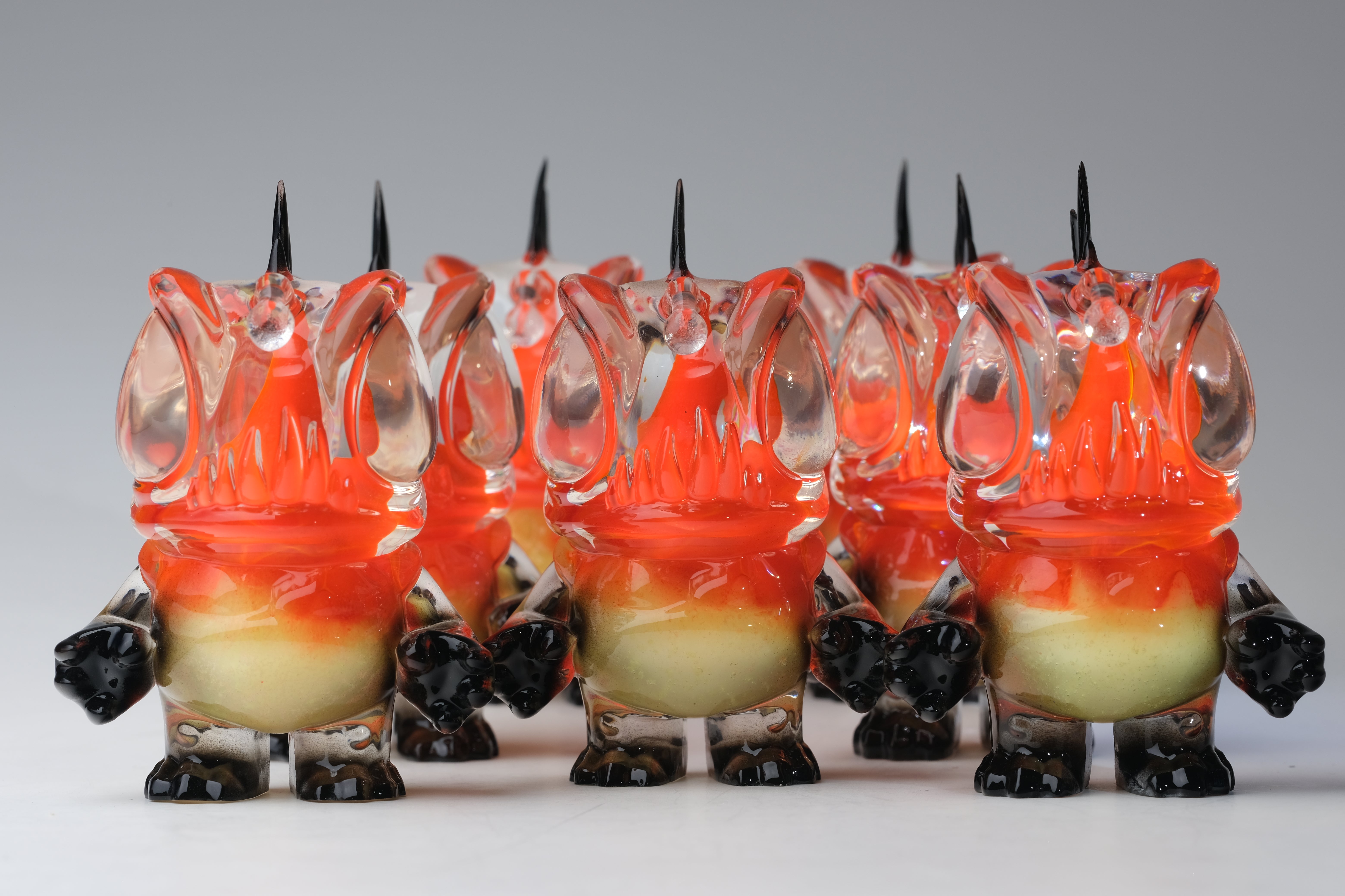 Angie Evo - Chicago Fire by 5th Turtle: Six translucent vinyl figures with orange-yellow gradient bodies, black accents, and kaiju-inspired faces, limited edition of 50 pieces.